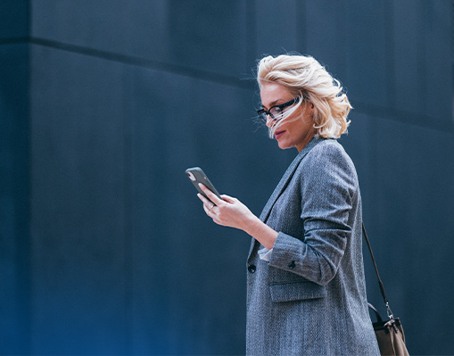 business woman walking and looking at mobile phone